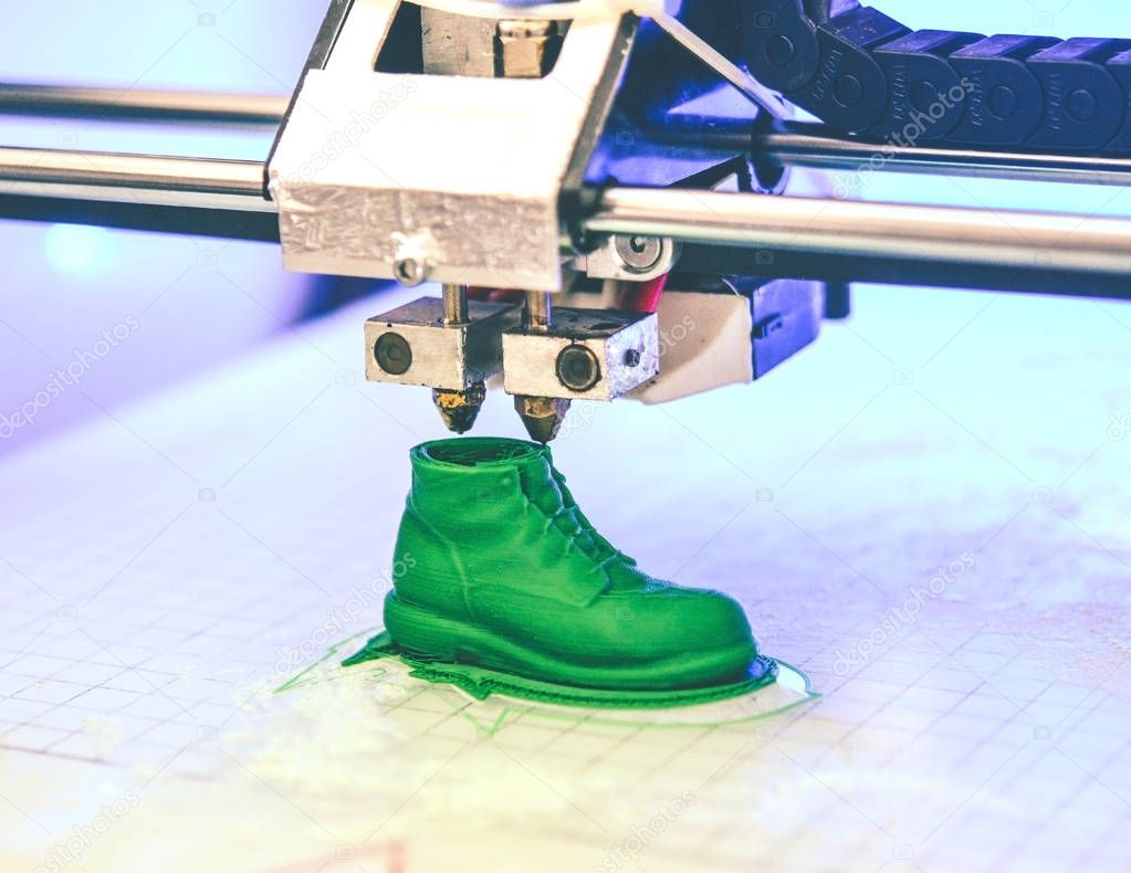 3D printer prints the form of molten plastic green.