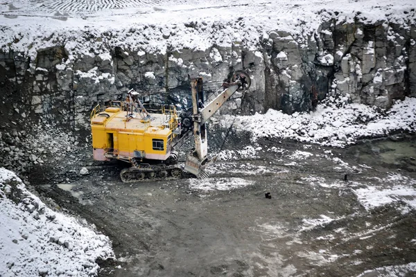 Gran excavadora amarilla enorme en granito cantera invierno —  Fotos de Stock