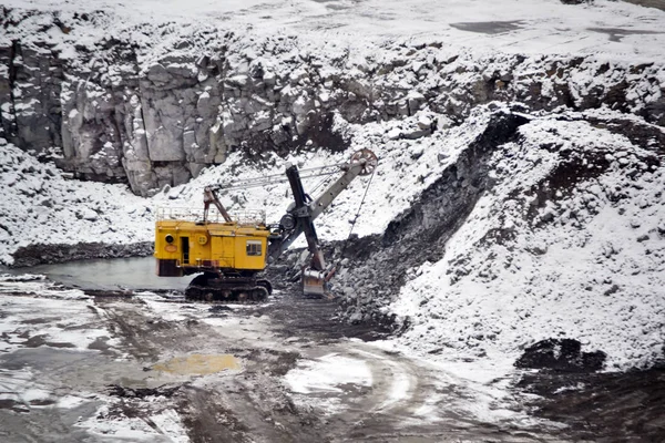 Gran excavadora amarilla enorme en granito cantera invierno — Foto de Stock