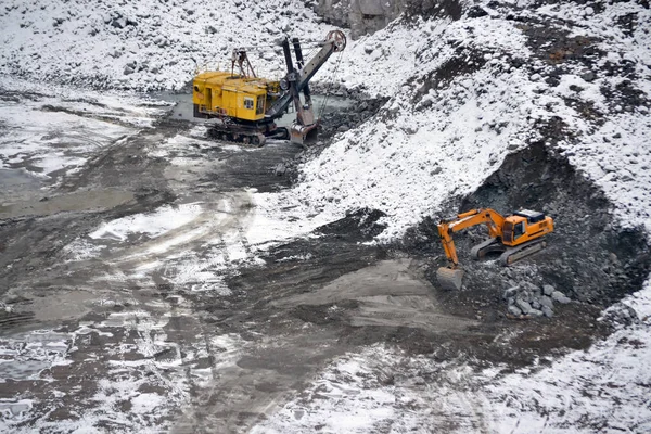 Gran excavadora amarilla enorme en granito cantera invierno — Foto de Stock