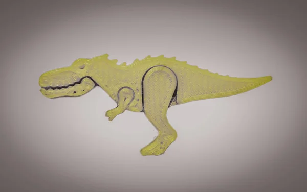 3d 프린터로 인쇄 된 공룡 장난감 모양의 밝은 녹색 물체 — 스톡 사진