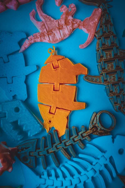 3d yazıcıya basılmış pek çok parlak renkli nesne düz yüzeyde yatıyor