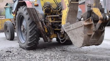 Traktör kazılmış çukurların yanında duruyor.