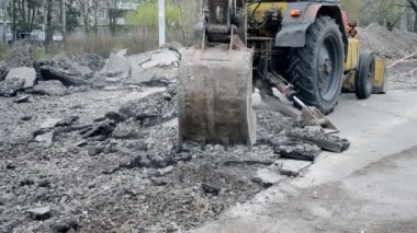 Traktör kovası asfaltı kırıyor.