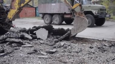 Traktör kovası asfaltı kırıyor.