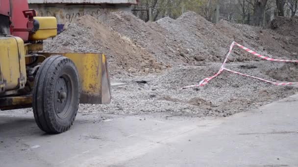 Εκσκαφέας στέκεται κοντά στα σκάγματα στο εργοτάξιο. — Αρχείο Βίντεο