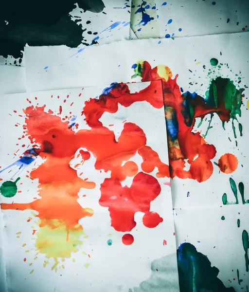 many red colored blots on white paper with streaks