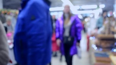 Birçok kişi aydınlatma ile alışveriş merkezi veya mağaza içinde yürümek.