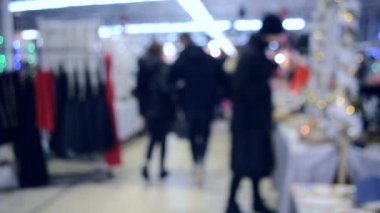 Birçok kişi aydınlatma ile alışveriş merkezi veya mağaza içinde yürümek.