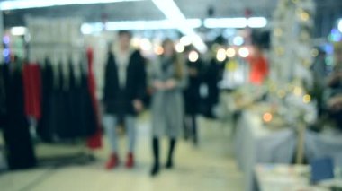 Birçok kişi aydınlatma ile alışveriş merkezi veya mağaza içinde yürümek.