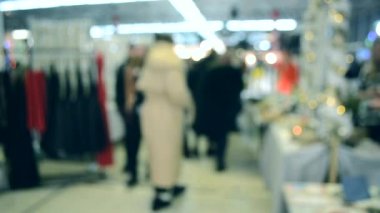 Birçok kişi aydınlatma ile alışveriş merkezi veya mağaza içinde yürümek.