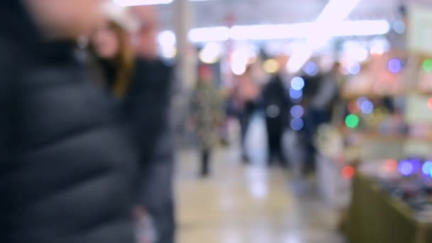 Wiele osób chodzić wewnątrz centrum handlowym lub sklepu z oświetleniem. — Wideo stockowe