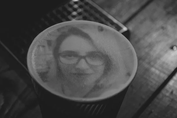 Рисунок лица женщины на кофе с пеной латте — стоковое фото