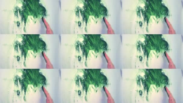 Girl draws hands on a white wall with green paint — Stock Video