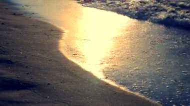 Güneşli yol deniz kıyısında ıslak kum üzerinde parıldar