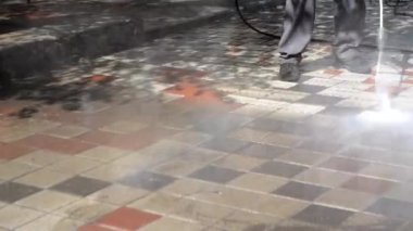Adam işçi yüksek basınç ve sıcaklık ile şehir kirli sokakları temizlik
