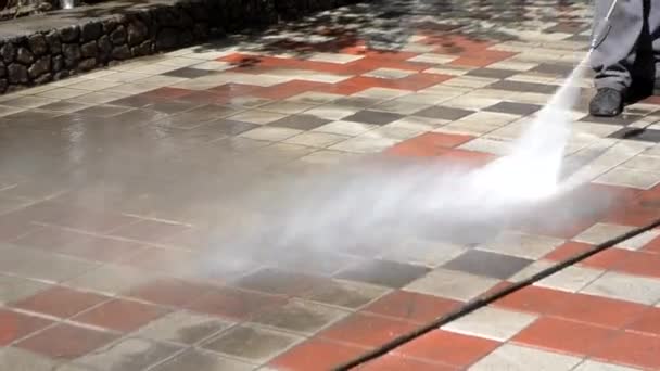 Man werknemer schoonmaken stad vuile straten met hoge druk en temperatuur — Stockvideo