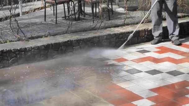 Man werknemer schoonmaken stad vuile straten met hoge druk en temperatuur — Stockvideo