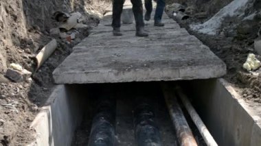 İnşaat vinç ile işçiler beton levhalar ile yeni su boruları kapağı