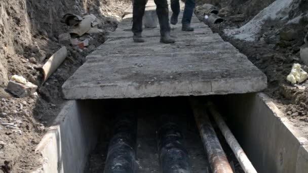 Trabalhadores com guindaste de construção cobrir novos tubos de água com lajes de concreto — Vídeo de Stock