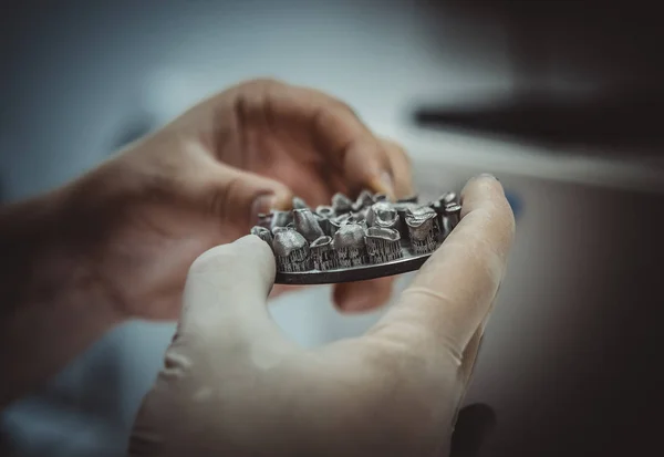 Человек держит в руках объект, отпечатанный на металлическом 3D принтере в лаборатории. — стоковое фото