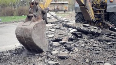 Traktör kovası asfaltı kırıyor.