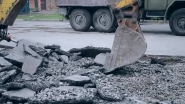 Traktör kovası asfaltı kırıyor.