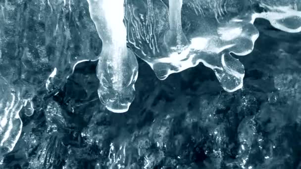 Het ontdooien van ijs aan de rand van een waterval beek close-up. Met geluid. — Stockvideo