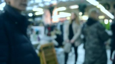 Birçok kişi aydınlatma ile alışveriş merkezi veya mağaza içinde yürümek.