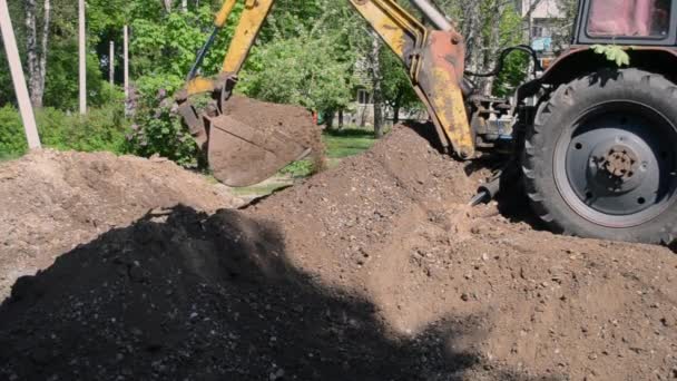 Backhoe stapelt de grond close-up op. — Stockvideo