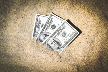 Kumsalda kumla kaplanmış paranın yarısı yakın planda duruyor. 300 dolar deniz veya okyanus sahilinde kumlara gömülü. Finans parası kavramı hariç. Tatil tatili gevşetir. Güneşli yaz ılık rüzgar günü.