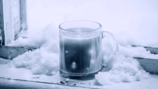Varmt kaffe med mjölk i glasmugg, som fylls med snö — Stockvideo