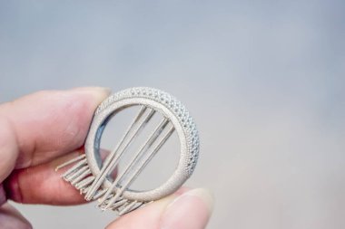 Adam metal 3D yazıcıya basılı nesne tutuyor. Nesne lazer sindirim makinesine basılmış. Metal tozundan modern 3D yazıcı baskısı. İlerici katkı maddesi DMLS, SLM, SLS 3D yazdırma teknolojisi