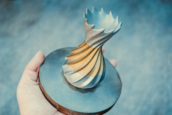 Человек держит объект, напечатанный на металлическом 3D принтере. Объект, отпечатанный в машине лазерного спекания. Современная 3D печать принтера из металлического порошка. Технология прогрессивной аддитивной печати DMLS, SLM, SLS 3d