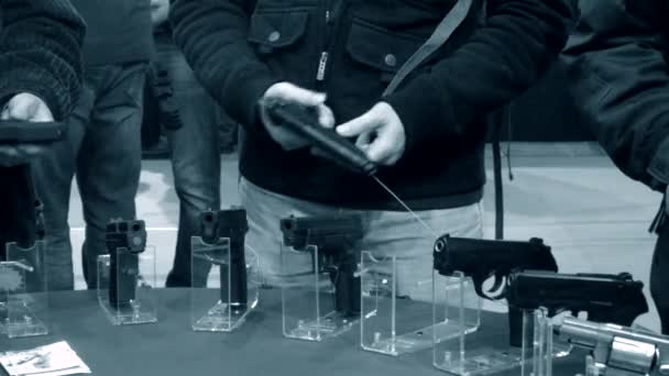 Много пистолетов на столе и руках — стоковое видео
