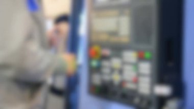 Kontrol panelinde çalışan adam endüstriyel bir makineyle çalışıyor.