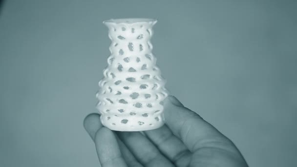 De persoon houdt zijn handen vast en bekijkt geel object gemaakt op 3d printer. — Stockvideo