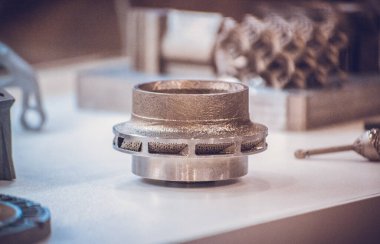 Metal 3D yazıcıya yazdırılmış nesneyi tutan adam