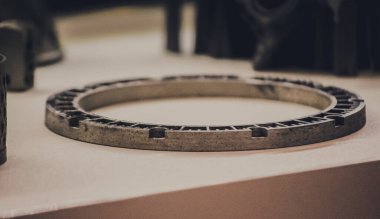 Metal 3D yazıcıya yazdırılmış nesneyi tutan adam.