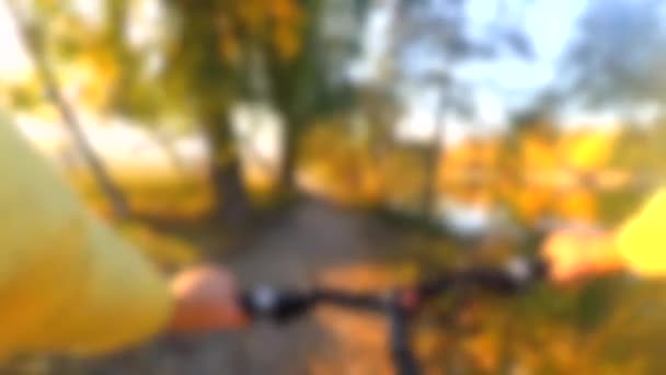 Fondo borroso. El hombre en bicicleta está cruzando el campo. — Vídeos de Stock
