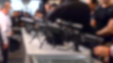 Arka plan bulanık. Masada makineli tüfek var..