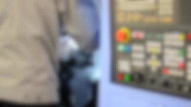 Kontrol panelinde çalışan adam endüstriyel bir makineyle çalışıyor.