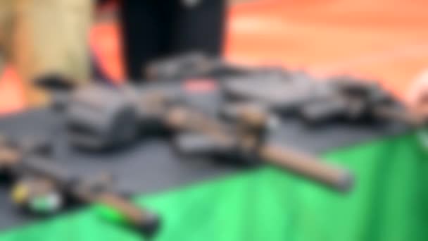 Unscharfer Hintergrund. Mehrere großkalibrige Waffen auf dem Tisch. — Stockvideo