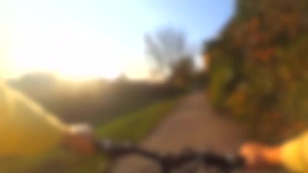 Blurred background. Extreme girl rides a bicycle along the river bank. — Stock Video