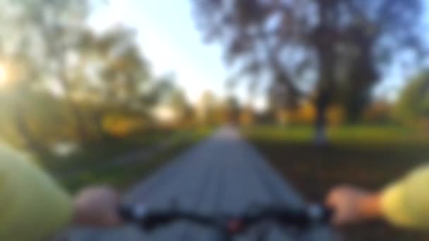 Fundo desfocado. Homem montando uma bicicleta em um campo em uma grama verde — Vídeo de Stock