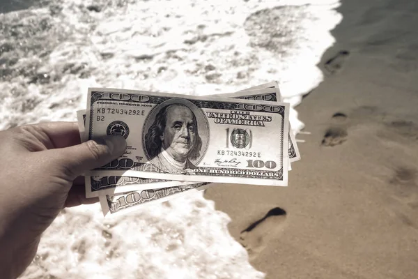 Meisje met geld rekening van 300 dollar op de achtergrond van de zee oceaan — Stockfoto