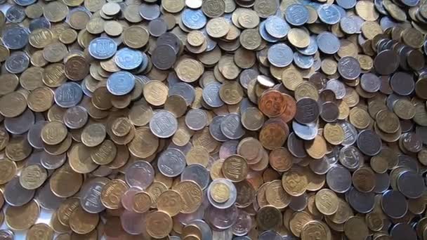 Persoon pakt een handvol munten in de hand en gooit het over munten op tafel. — Stockvideo