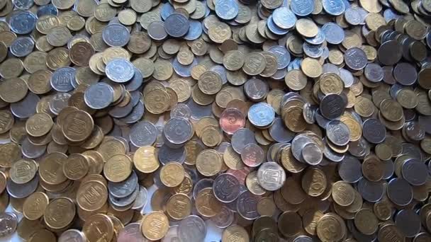 Chica recoge un puñado de monedas en su mano y lo lanza sobre monedas en la mesa — Vídeos de Stock