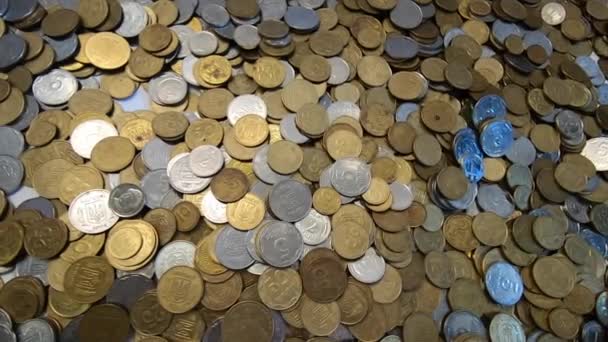 Person picks up handful of coins in hand and throws it over coins on table. — Stock Video