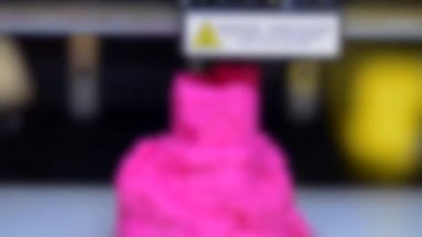 Arka plan bulanık. 3D yazıcı kapanışında pembe bir figür yazdır.